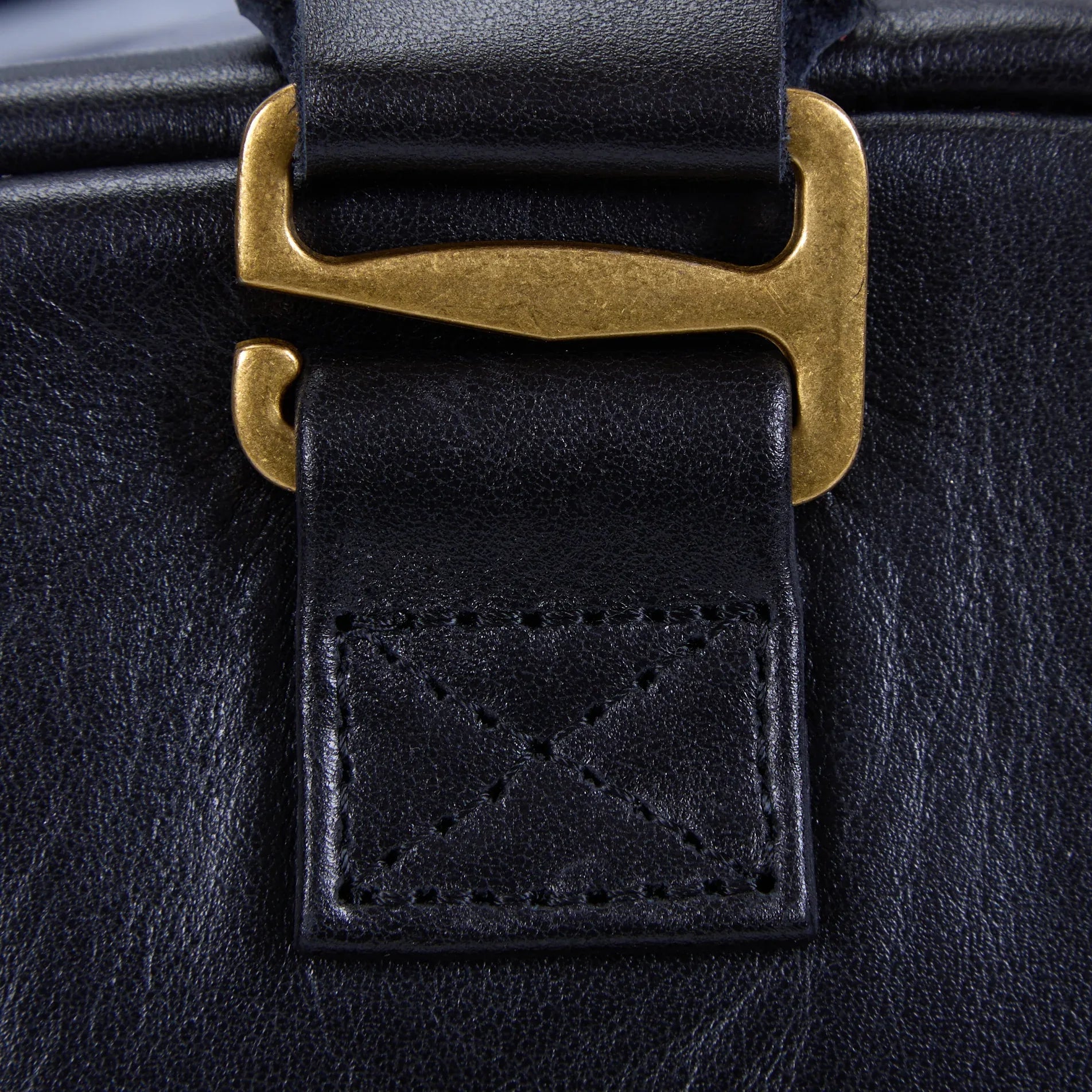 Bottom of Nomad black leather bag with structured base and metal feet protecting the leather